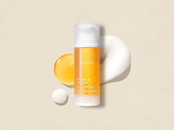 Orgahue Vitamin B Cleanser with cleansing foam on a warm neutral background